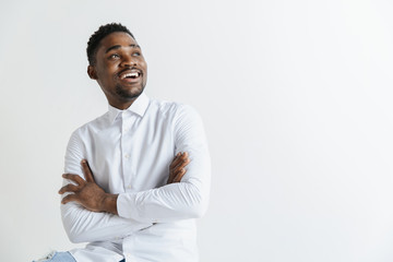 Close up portrait of a happy excited young african american man laughing against gray background. - Powered by Adobe