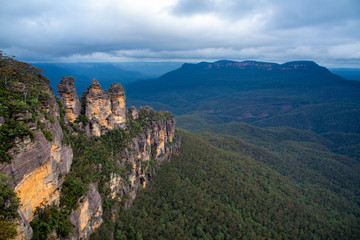 Fototapeta na wymiar Three Sisters landmark rock formation in Blue Mountains National Park, near Sydney, New South Wales, Australia, cloudy sky, valley overlook