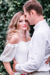 Fototapeta premium Bride and groom with a bouquet of peonies posing against the backdrop of the forest