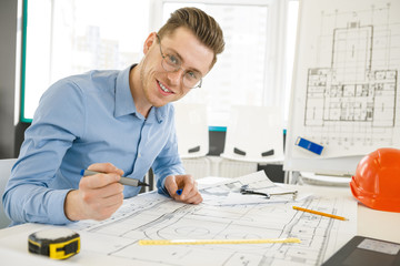 Young male architect working at his office
