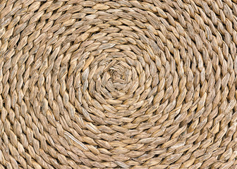 Closeup of circle plait handcraft weave texture from natural wicker. Undyed surface round wicker straw background. Texture of rattan weave macro