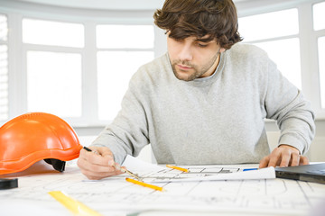 Young male architect working at his office