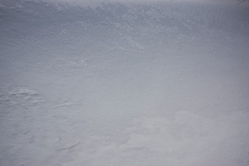 Snow and wind combined formed snow waves in a agricultural environment.