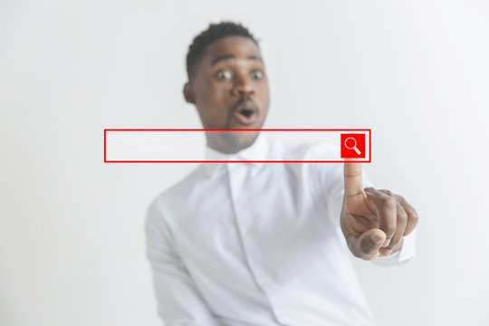 Handsome businessman pointing his finger to the camera and slicking virtual button, finger is in focus while his face is out of focus. Shallow depth of field. Young african american guy interacts with