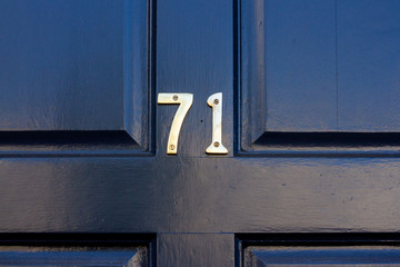 HOuse number 71 with the seventy one in bronze on a beautifully painted black wooden door