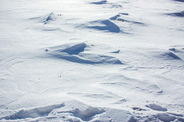 Fototapeta na wymiar Snow and wind combined formed snow waves in a agricultural environment.
