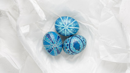 Pysanky on the white crumpled paper background