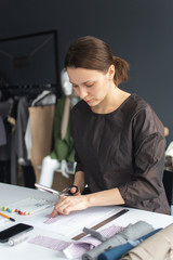 Female dressmaker marking out pattern on cloth 