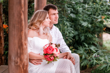 Bride and groom are sitting on the threshold of a wooden house