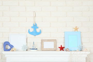 White fireplace with photo frame, decorative ship and seashells