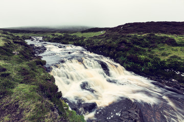 River in Isle of Skye, Scotland, flowing over rapids with rocks artistic conversion