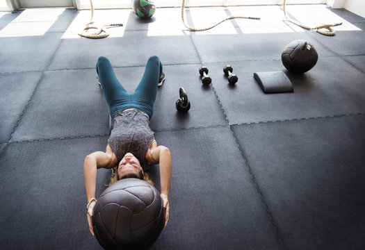 Focused athlete exercising with medicine ball in gym