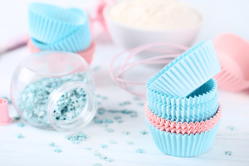 Fototapeta na wymiar Colorful cupcake cases with sprinkles on white background