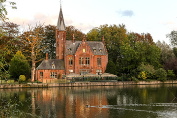 Obraz premium An old belgian castle along the canal in Bruges, Belgium