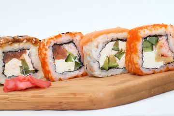 set of four sushi rolls on a wooden Board.