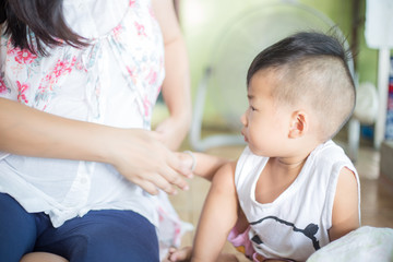 Happy child boy playing with pregnant mother