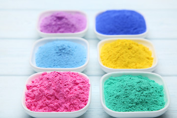 Colorful holi powder in bowls on wooden table