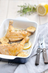 Chicken legs with lemon, thyme and garlic. Chicken legs cooked on the grill. Close-up. Light wooden background. Vertical frame orientation.