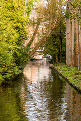 Fototapeta na wymiar Bruges, Belgium - October 10, 2014: Beautiful view of tourists taking a boat ride through the historic city center of Brugge, province of West Flanders, Belgium