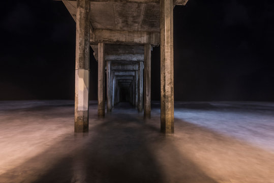 View of wooden pier on beach at night