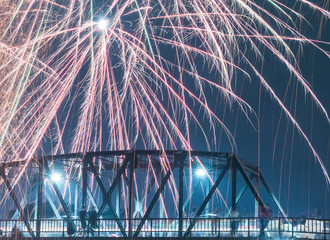 Low angle view of firework display over bridge in sky