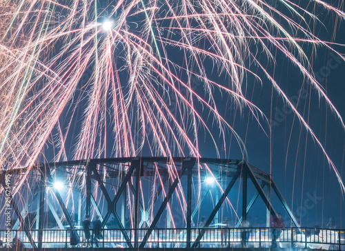 Low angle view of firework display over bridge in sky