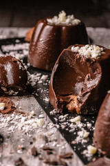 dark chocolate and biscuit pudding. White chocolate and cocoa decorations. Spoonful to show the inside 