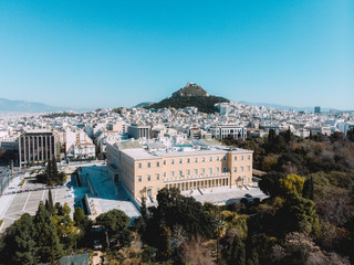 Fototapeta premium City views of day time with acropolis on a hill at the horizon, Athens, Greece