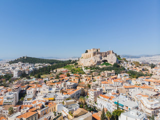 Fototapeta premium City views of day time with acropolis on a hill at the horizon, Athens, Greece