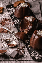 dark chocolate and biscuit pudding. White chocolate and cocoa decorations. Spoonful to show the inside 