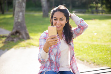 Cheerful student girl using smartphone for video call