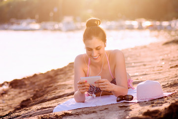 woman using phone on beach