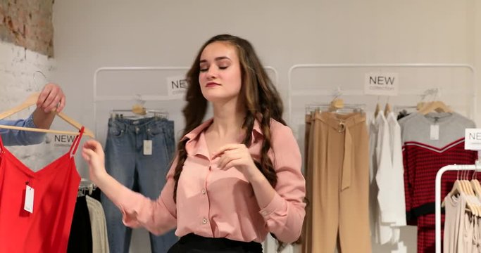 Young woman possing and trie on clothes at store