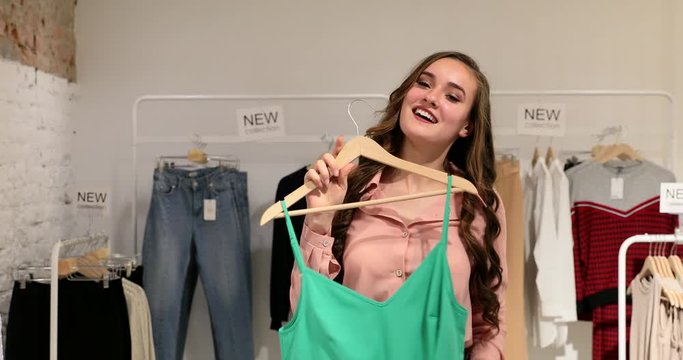Young woman tries on clothes at store