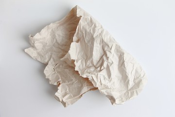 A piece of crumpled paper is folded in half on a light background.