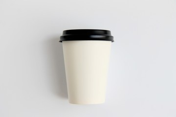 paper cup with black lid on a light background