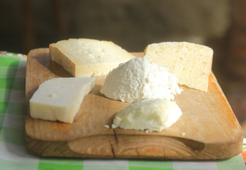different types of cheese on a wooden cutting board