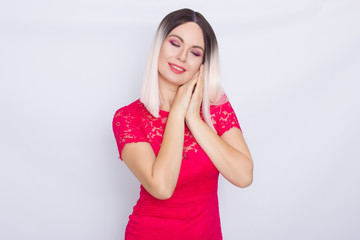 Young blonde woman over white background in bright pink dress