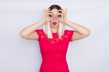 Young blonde woman over white background in bright pink dress