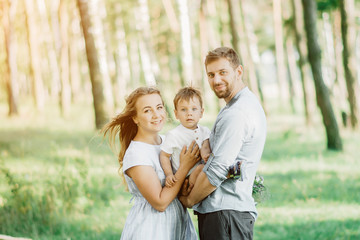 Happy young family spending time together outside in green nature