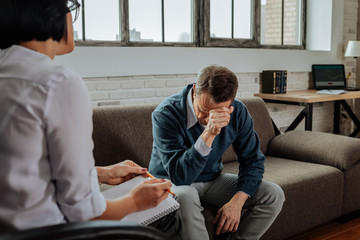 Despaired short-haired patient having mental issues and explaining them