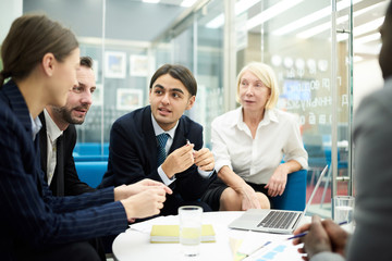Group of business people discussing work actively during meeting in office , copy space