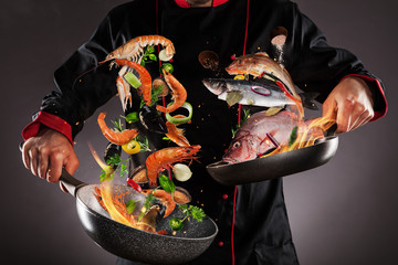 Closeup of chef throwing sea fruit and fish