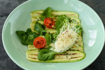 Salad from zucchini slices with cherry tomato, cream cheese and micro greens. Vegetarian food