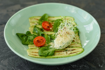Salad from zucchini slices with cherry tomato, cream cheese and micro greens. Vegetarian food