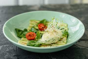Salad from zucchini slices with cherry tomato, cream cheese and micro greens. Vegetarian food