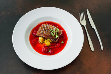 Steak  from fillet of a duck with caramelized strawberry and an eggplant