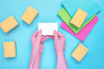 Cleaning concept A set of cleaning tools, rags, sponges, brushes, hands in rubber gloves on a light...
