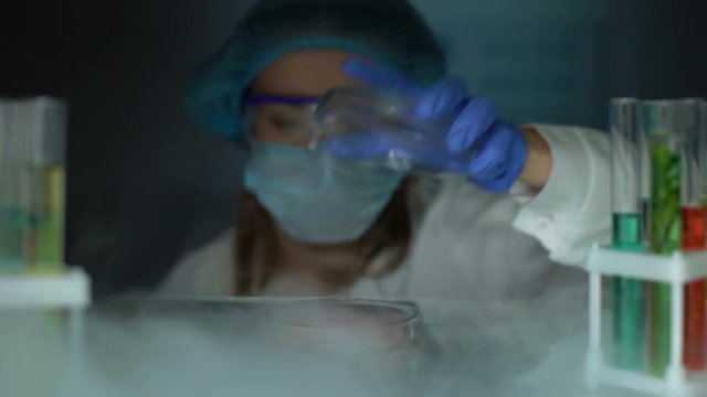 Researcher taking meat sample in petri dish from fridge and making injection