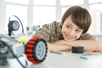 Young boy building a robot managed from a constructor
